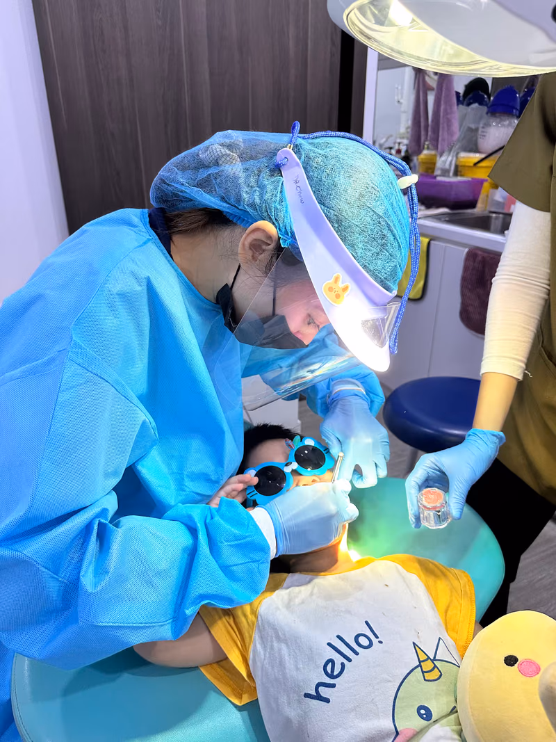 Pediatric dentist treating a young child during a comfortable and friendly kids dental appointment.