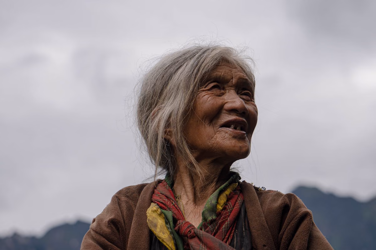 An older woman looking out thoughtfully, representing the health-based assessment that decides whether full-arch implants are suitable.