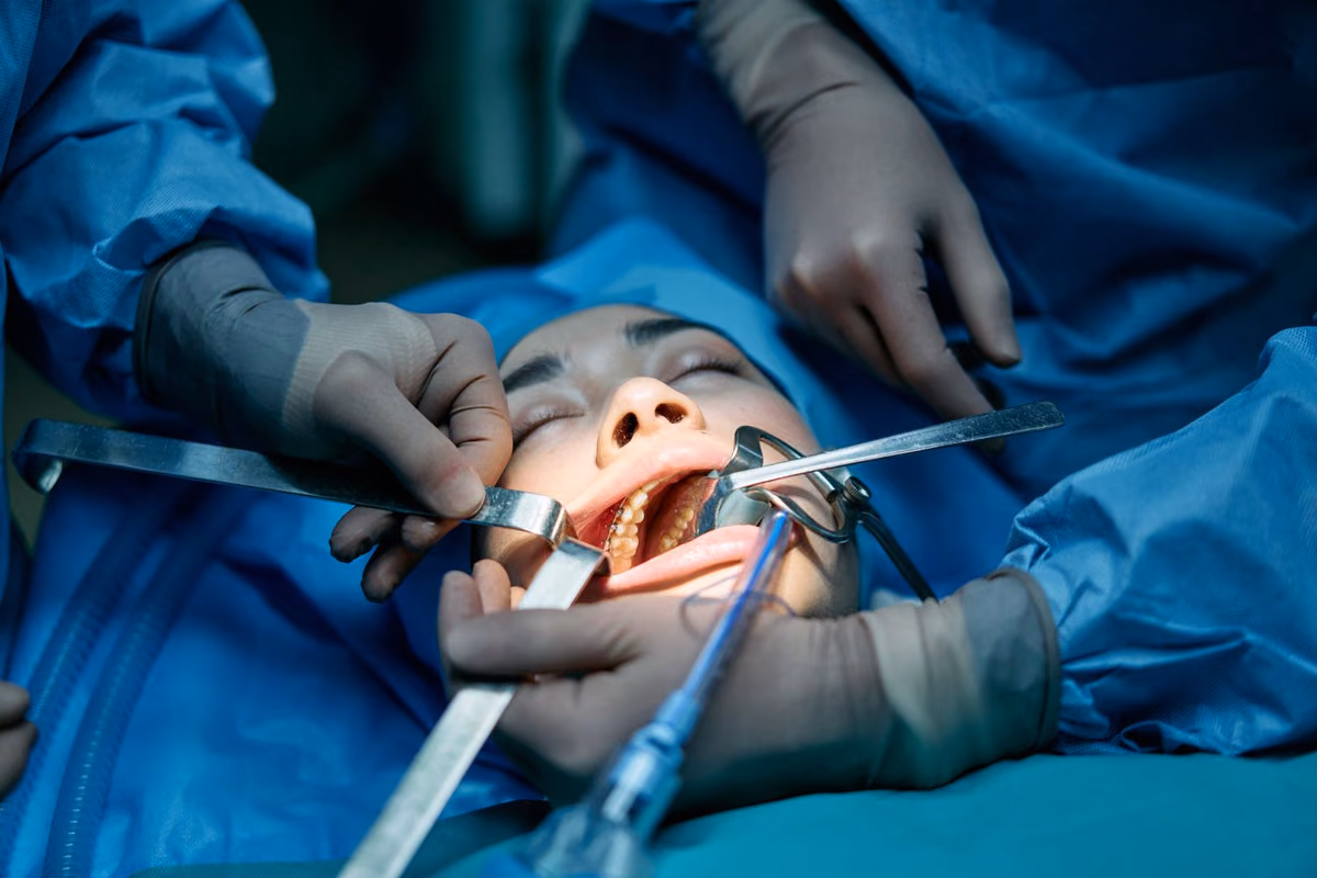 A dental team carrying out a surgical procedure on a patient, the setting in which a failed implant is removed and the site prepared again.