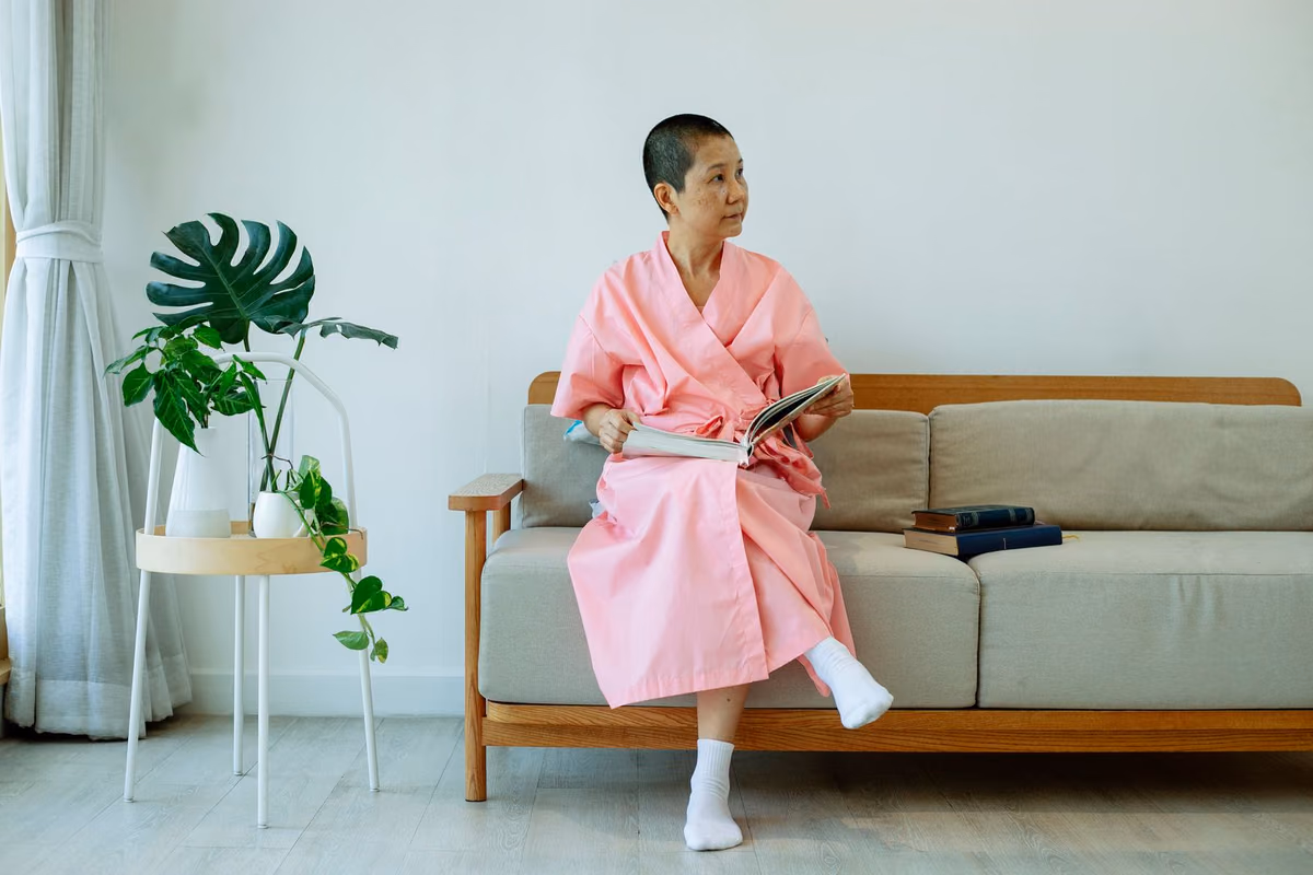 A woman resting at home with a book after a dental procedure, the quiet few days of recovery that follow a bone graft.
