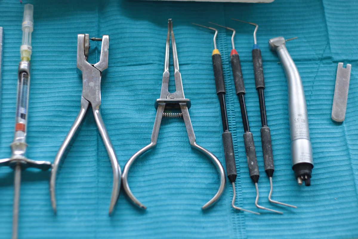 Sterile dental surgical instruments laid out on a teal cloth, the setup used for bone grafting and implant placement procedures.