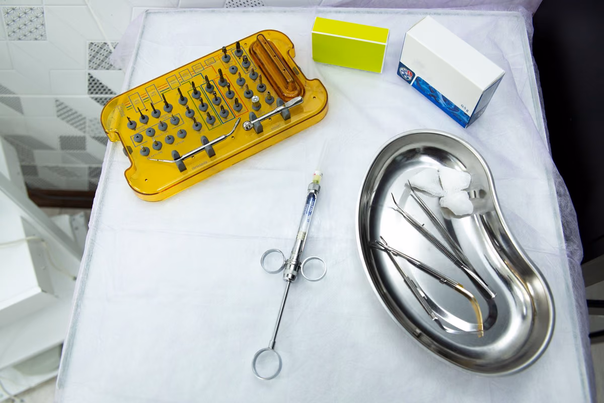 A sterile dental implant surgical kit with drivers and instruments laid out on a tray, the equipment behind why implant quotes vary between clinics.