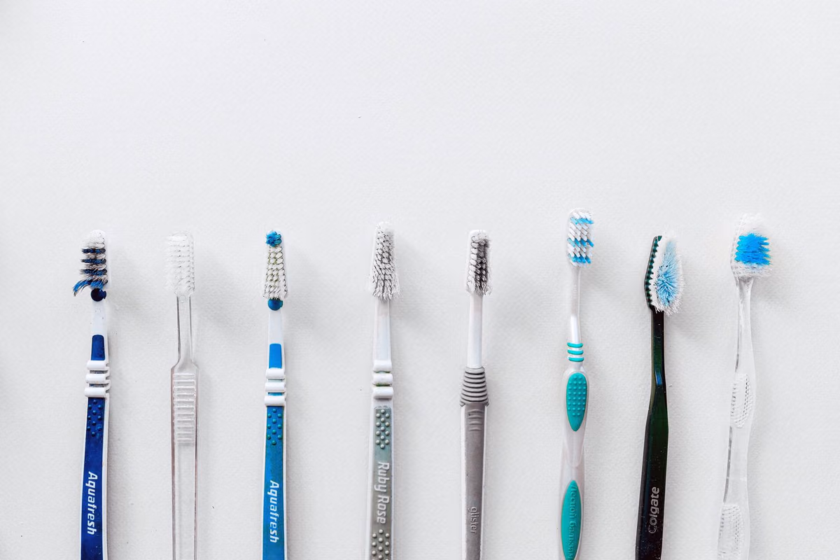 A row of toothbrushes lined up, representing the daily cleaning routine that differs sharply between fixed braces and removable aligners.