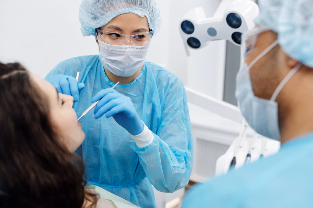 A dentist examining a patient in a modern clinic, the assessment that determines which type of invisible braces suits an individual case.